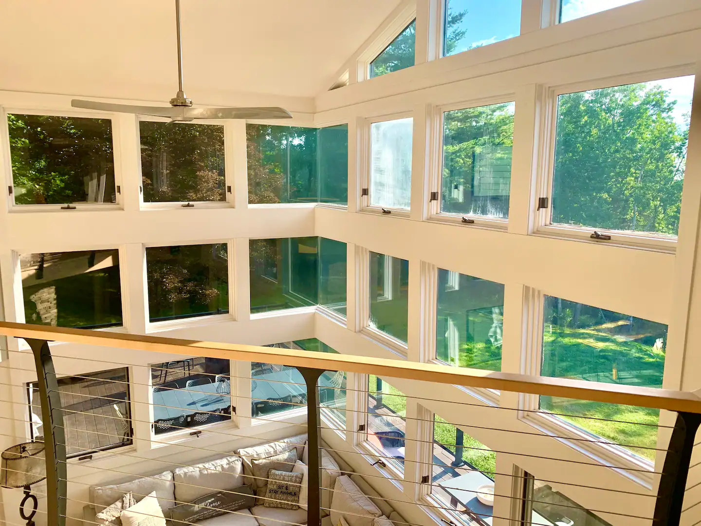 Multi-story windows and interior balcony overlooking the woods